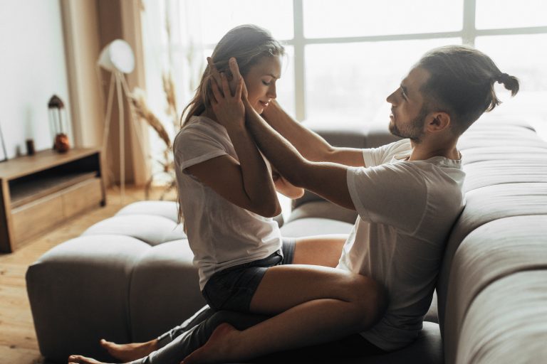 Young romantic couple is kissing and enjoying the company of each other at home