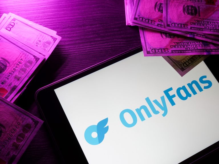 KYIV, UKRAINE - May 4, 2022. Tablet with onlyfans logo and money